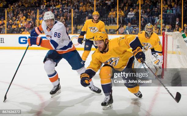 Yannick Weber of the Nashville Predators skates against Nikolay Kulemin of the New York Islanders during an NHL game at Bridgestone Arena on October...
