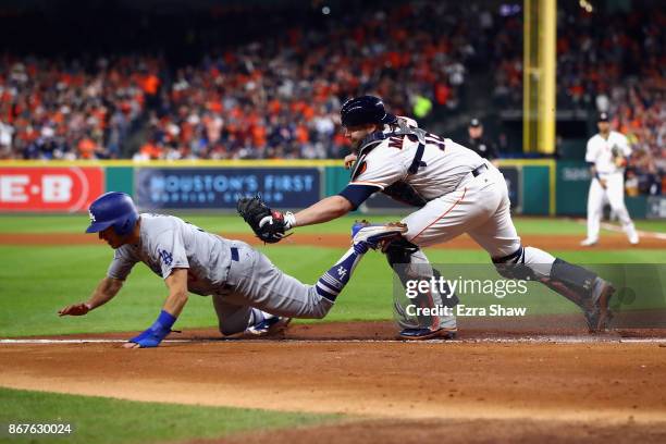 Austin Barnes of the Los Angeles Dodgers is tagged out trying to score by Brian McCann of the Houston Astros during the sixth inning in game four of...