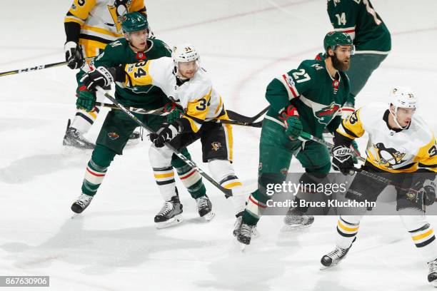 Mike Reilly and Kyle Quincey of the Minnesota Wild battle for position with Tom Kuhnhackl and Greg McKegg of the Pittsburgh Penguins during the game...