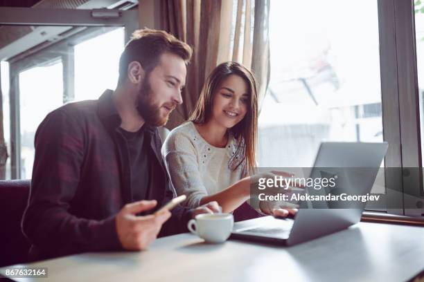 smiling couple drinking coffee and making video conference in the morning - voice search stock pictures, royalty-free photos & images