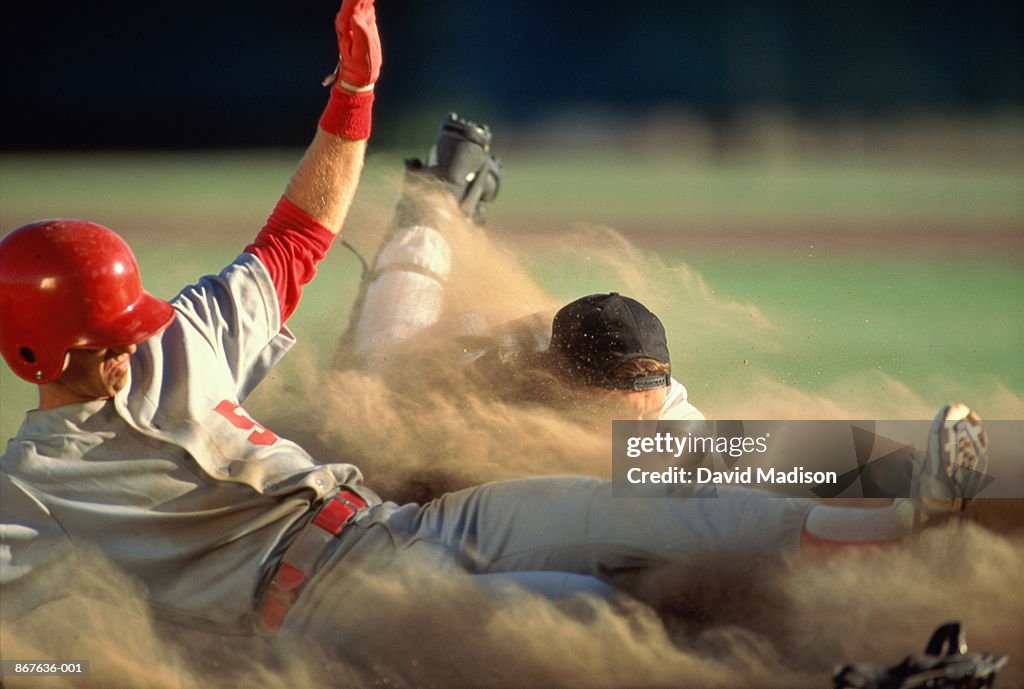 Baseball, player sliding into home plate, catcher trying to tag