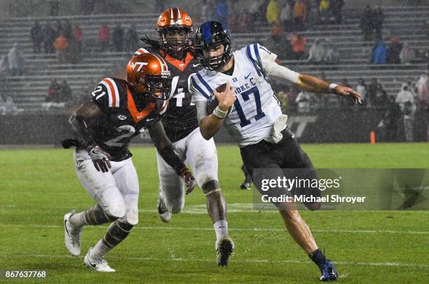 Quarterback Daniel Jones of the Duke Blue Devils is pursued by safety Reggie Floyd and linebacker Tremaine Edmunds of the Virginia Tech Hokies in the...