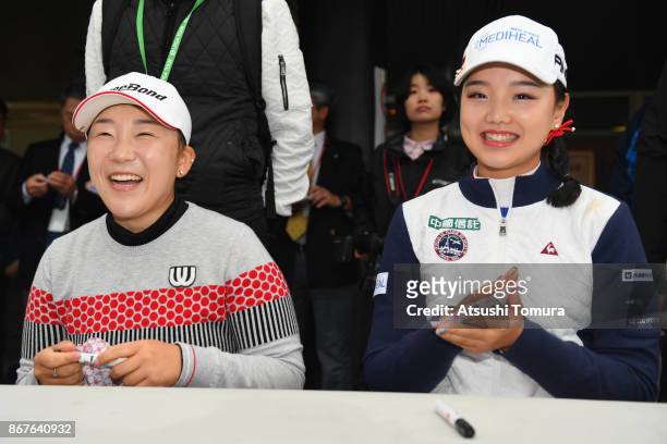 Jiyai Shin of South Korea and Yuting Seki of China attend autograph session after the final day has cancelled because of rain storm during the final...