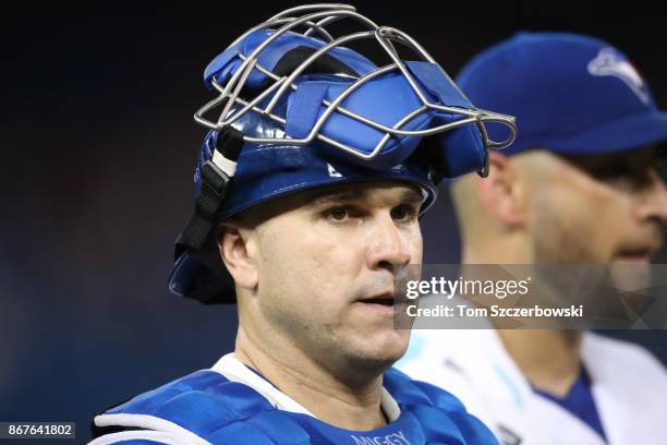 Miguel Montero of the Toronto Blue Jays and Marco Estrada walk from the bullpen to the dugout before the start of MLB game action against the Oakland...