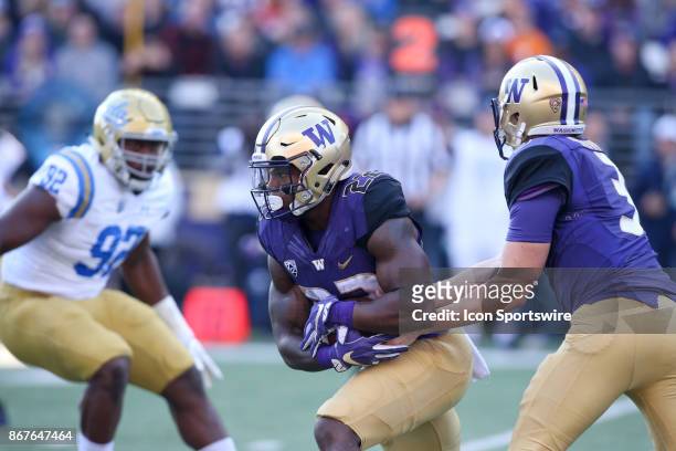 Washington's Lavon Coleman breaks through a hole at the line of scrimmage during a college football game between the Washington Huskies and the UCLA...