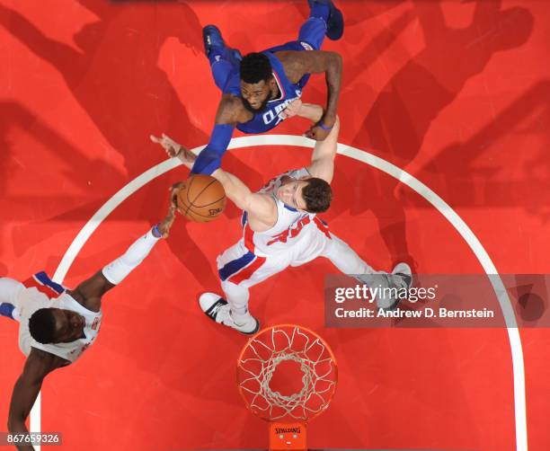 Willie Reed of the LA Clippers goes up for a rebound against Jon Leuer and Reggie Jackson of the Detroit Pistons on October 28, 2017 at STAPLES...