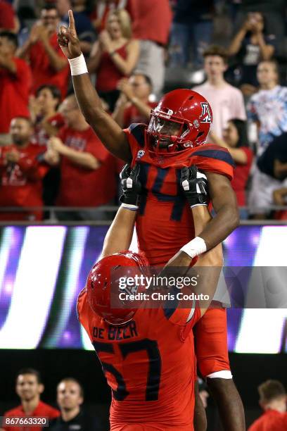 Quarterback Khalil Tate of the Arizona Wildcats reacts with offensive lineman Gerhard de Beer after scoring a second half touchdown during the...