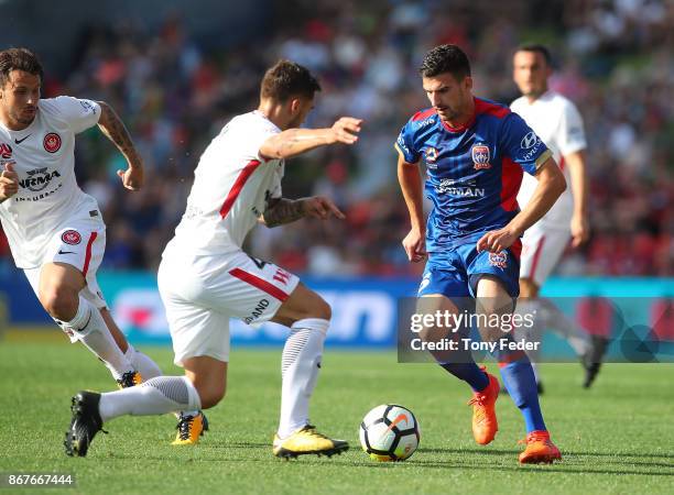 Steven Ugarkovic of the Jets contests the ball with Alvaro Cejudo of the Wanderers during the round four A-League match between the Newcastle Jets...