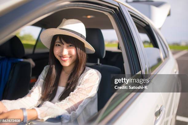 happy young woman waiting in passenger seat to go for a drive - straw hat stock pictures, royalty-free photos & images