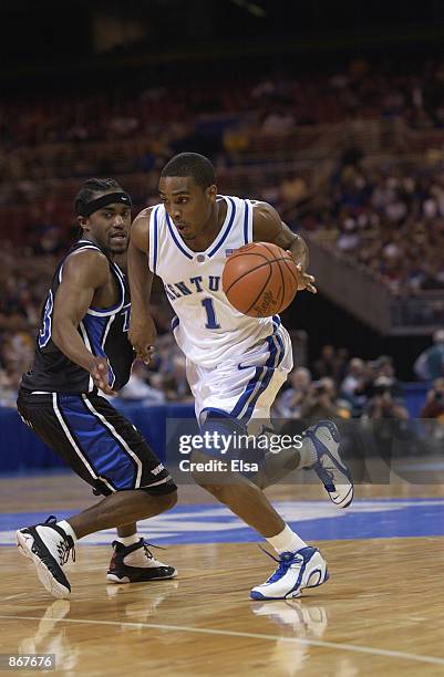 Guard Cliff Hawkins of the Kentucky Wildcats drives past guard Antonio Reed of the Tulsa Golden Hurricanes during the second round of the 2002 NCAA...