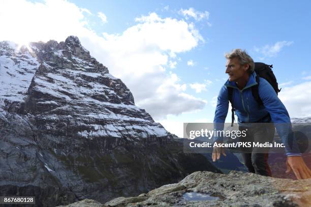 mountaineer follows route to summit, below mountains - eiger stock-fotos und bilder