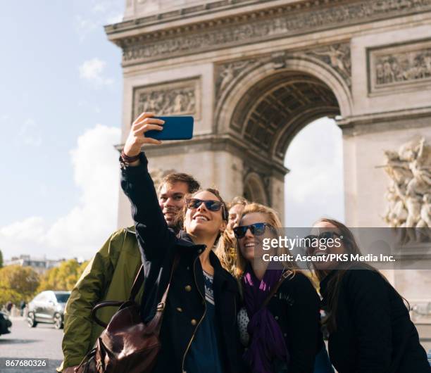group of friends pose for selfie in front of the arc de triomphe - tourist group foto e immagini stock