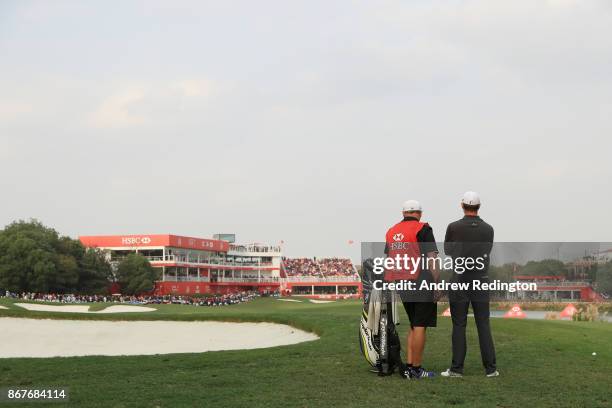 Justin Rose of England and caddie Mark Fulcher prepares to play a shot on the 18th hole during the final round of the WGC - HSBC Champions at Sheshan...