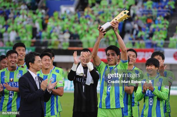 Captain Shunsuke Kikuchi of Shonan Bellmare lifts the trophy as they celerbrate J2 champions and promotion to J1 after the J.League J2 match between...