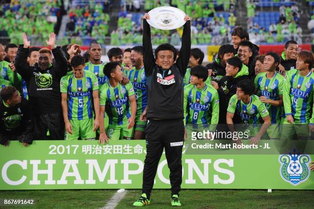 Head coach Cho Kwi Jae of Shonan Bellmare lifts the trophy as they celerbrate J2 champions and promotion to J1 after the J.League J2 match between...