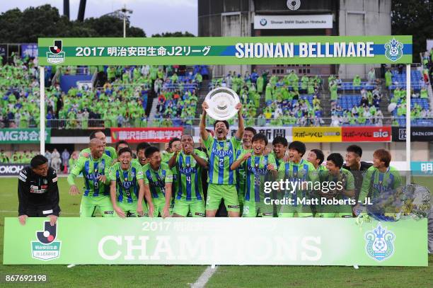 Captain Shunsuke Kikuchi of Shonan Bellmare lifts the trophy as they celerbrate J2 champions and promotion to J1 after the J.League J2 match between...