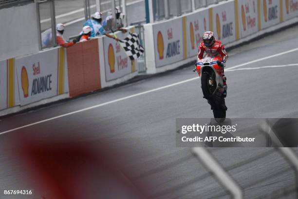 Ducati Team's Italian rider Andrea Dovizioso celebrates winning the Malaysia MotoGP at the Sepang International circuit in Sepang on October 29,...