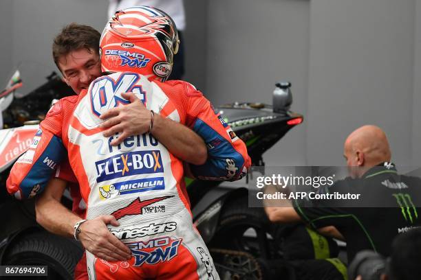 Ducati Team's Italian rider Andrea Dovizioso celebrates with a teammate after winning the Malaysia MotoGP at the Sepang International Circuit in...