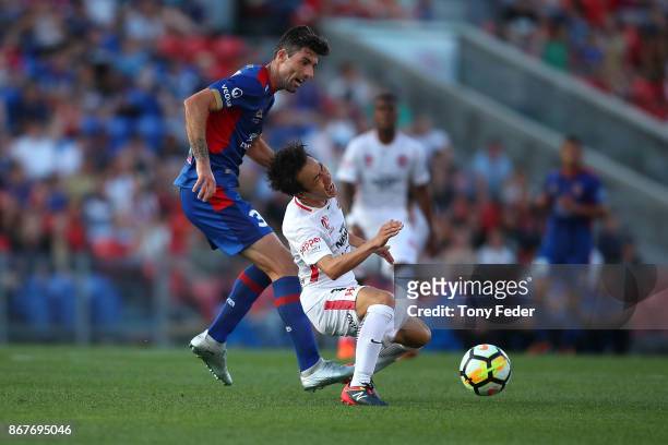 Jason Hoffman of the Jets contests the ball with Jumpei Kusukami of the Wanderers round four A-League match between the Newcastle Jets and the...