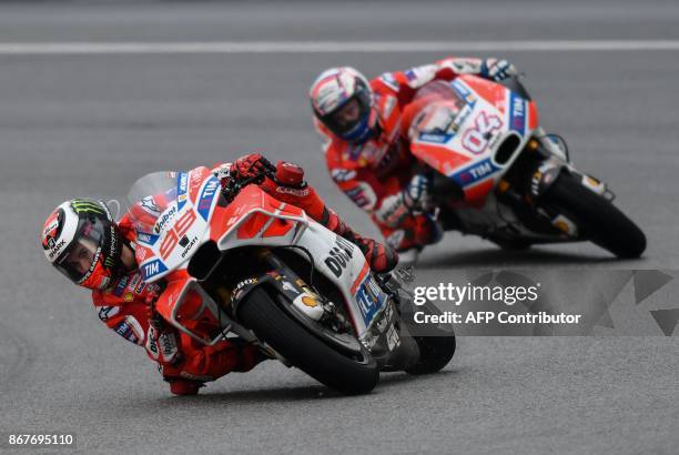 Ducati Team's Spanish rider Jorge Lorenzo and Ducati Team's Italian rider Andrea Dovizioso compete during the Malaysia MotoGP at the Sepang...