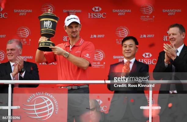 Justin Rose of England celebrates with the Old Tom Morris Cup on the Champion's Balcony after finishing 14 under to win the WGC - HSBC Champions at...
