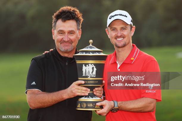 Justin Rose of England celebrates with the Old Tom Morris Cup and caddie Mark Fulcher after finishing 14 under to win the WGC - HSBC Champions at...