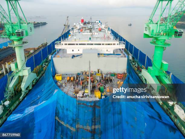 aerial view shipyard have crane machine and container ship in green sea . - elemento vasale foto e immagini stock