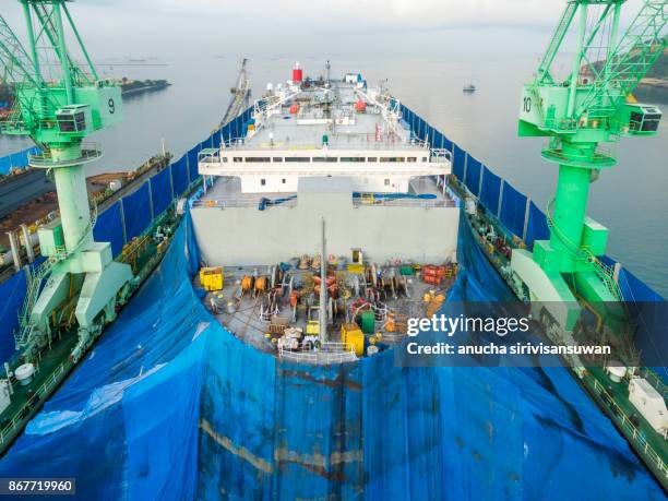 aerial view shipyard have crane machine and container ship in green sea . - ship builders stock pictures, royalty-free photos & images