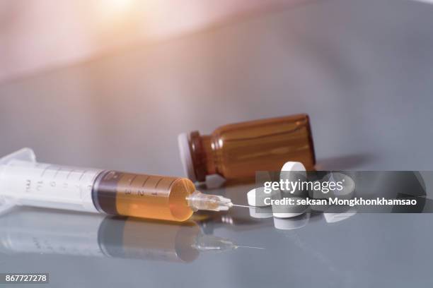 drug syringe and cooked heroin on spoon - opioid stockfoto's en -beelden