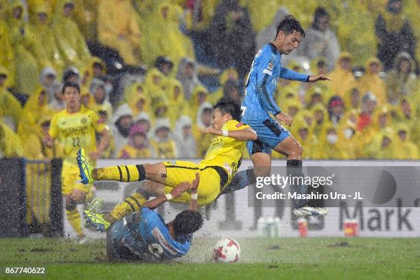 Shinnosuke Nakatani of Kashiwa Reysol is challenged by Takayuki Morimoto and Kei Chinen of Kawasaki Frontale during the J.League J1 match between...