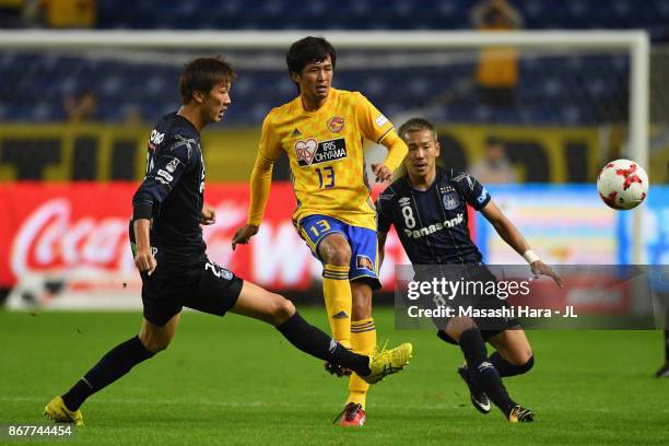 Yasuhiro Hiraoka of Vegalta Sendai controls the ball under pressure of Shun Nagasawa and Yosuke Ideguchi of Gamba Osaka during the J.League J1 match...