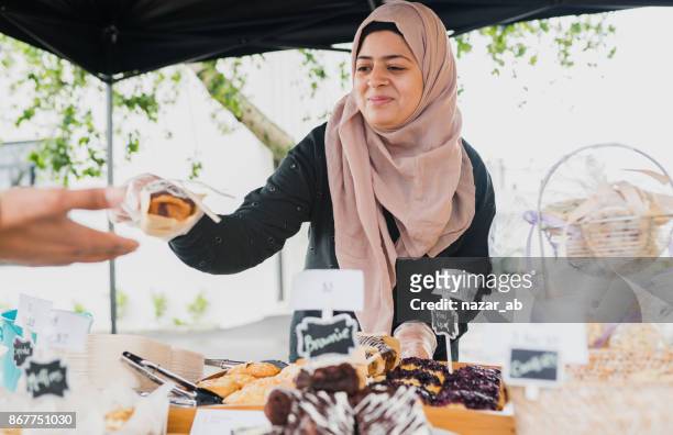 Muslim woman serving customer.