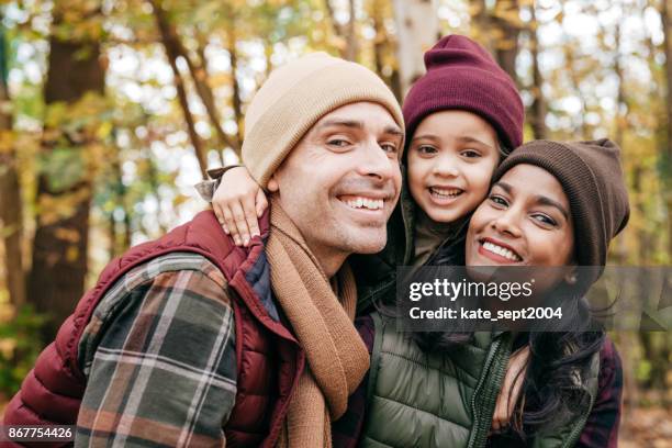 family close up portrait in warm clothes at the park - diverse family stock pictures, royalty-free photos & images