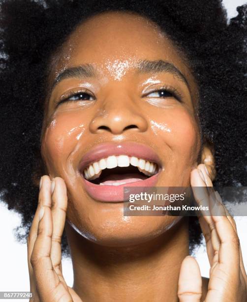 young female applying moisturiser - woman face cleaning stock pictures, royalty-free photos & images