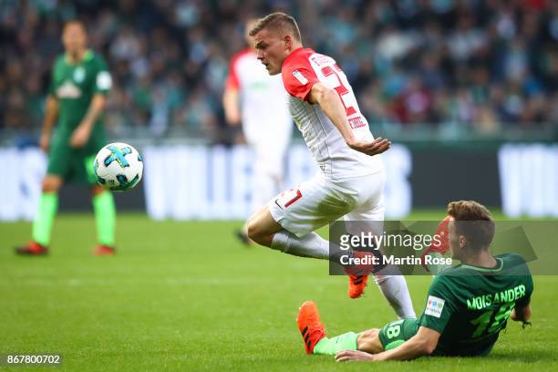 Niklas Moisander of Bremen and Alfred Finnbogason of Augsburg battle for the ball during the Bundesliga match between SV Werder Bremen and FC...