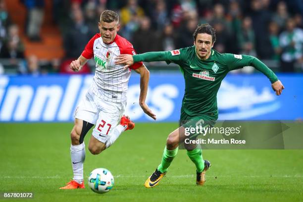 Alfred Finnbogason of Augsburg and Thomas Delaney of Bremen battle for the ball during the Bundesliga match between SV Werder Bremen and FC Augsburg...