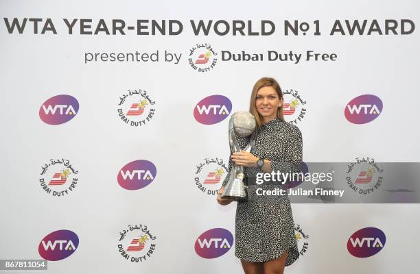 Simona Halep of Romania poses with the WTA Year-End World No.1 Award presented by Dubai Duty Free during day 8 of the BNP Paribas WTA Finals...