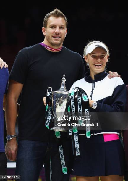 Caroline Wozniacki of Denmark celebrates victory with the Billie Jean King trophy and American profesional basketball player David Lee after the...