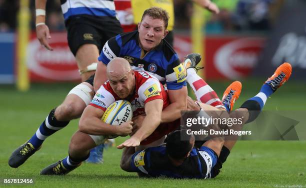 Willi Heinz of Gloucester is tackled by Sam Underhill and Kahn Fotuali'i during the Aviva Premiership match between Bath Rugby and Gloucester Rugby...