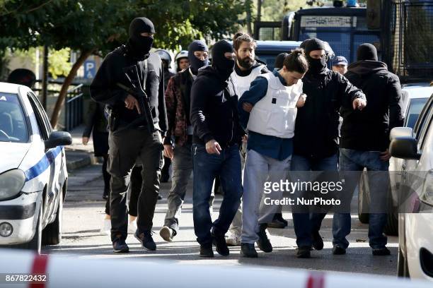 Police officers escort two suspects to the prosecutor's office in Athens on Sunday October 29, 2017. A 29 year old man is accused of having sent the...