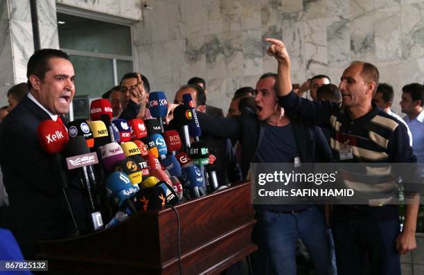 Iraqi Kurdish men protest as Rabon Maarouf, an independent member of Kurdistan's parliament, gives a press conference outside the parliament, in...