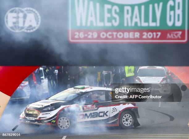 British pilot Elfyn Evans and co pilot Daniel Barritt of the M-Sport World Rally celebrate in their Ford Fiesta WRC by 'pulling doughnuts' after...