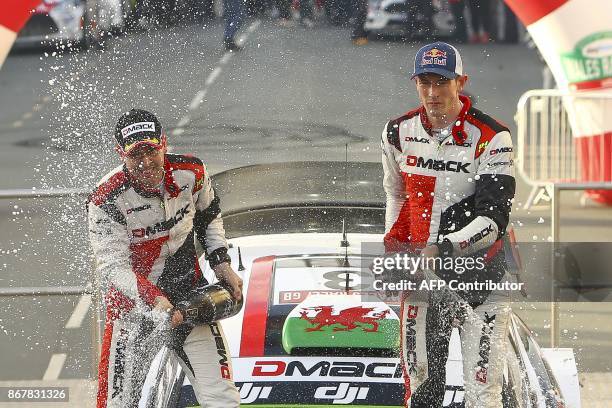 British pilot Elfyn Evans and co pilot Daniel Barritt of the M-Sport World Rally spray champagne as they celebrate on their Ford Fiesta WRC after...