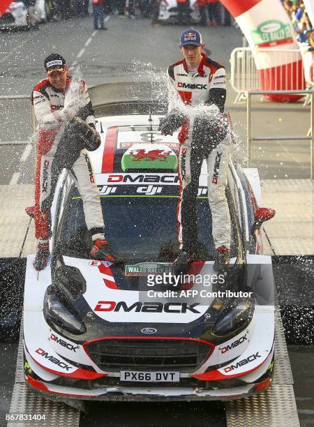 British pilot Elfyn Evans and co pilot Daniel Barritt of the M-Sport World Rally spray champagne as they celebrate on their Ford Fiesta WRC after...