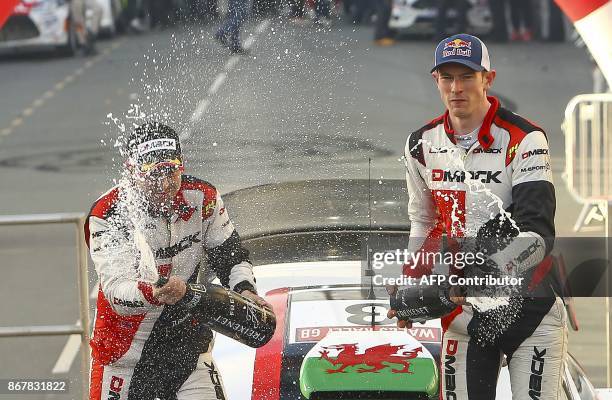 British pilot Elfyn Evans and co pilot Daniel Barritt of the M-Sport World Rally spray champagne as they celebrate on their Ford Fiesta WRC after...