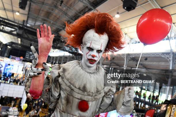 Cosplayers dressed as Pennywise from "It" poses during the Comic Con festival on October 29, 2017 at the Grande Halle de la Villette in Paris.