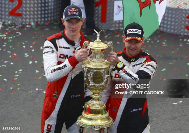 British pilot Elfyn Evans and co pilot Daniel Barritt of the M-Sport World Rally hold up their trophy as they celebrate after winning the 2017 Wales...