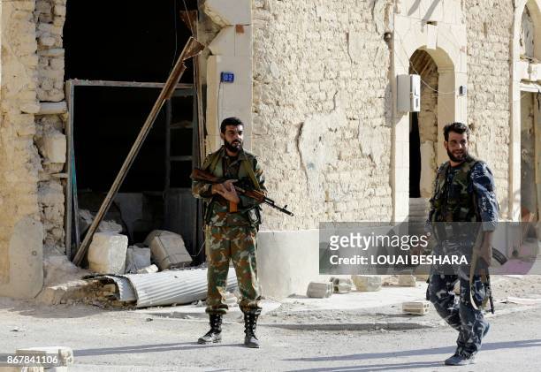 Syrian forces stand guard in the desert town of Al-Qaryatain on October 29 after troops retook it from Islamic State group fighters. Regime forces...