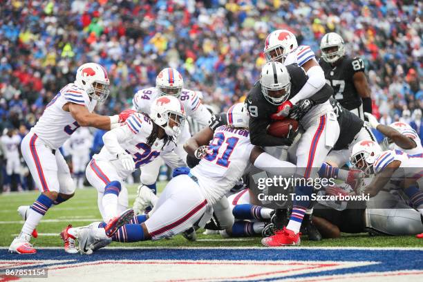 Jamize Olawale of the Oakland Raiders is tackled by Cedric Thornton of the Buffalo Bills and Preston Brown of the Buffalo Bills as he scores a...