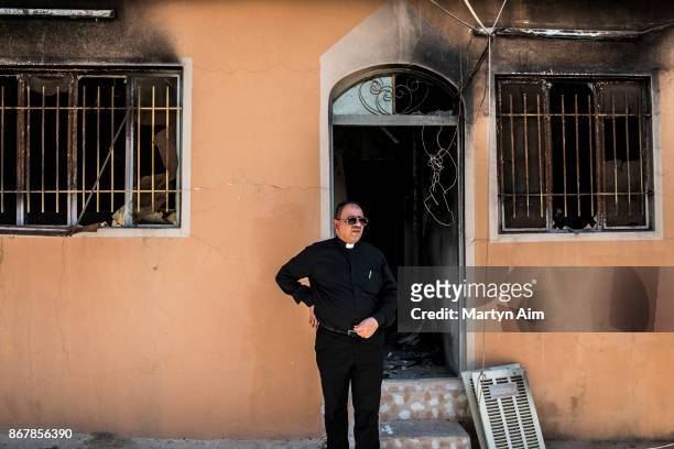 Chaldean Catholic Father Thadet outside a residence damaged and burned by Islamic State militants in Karamles, a Christian town in northern Iraq, on...